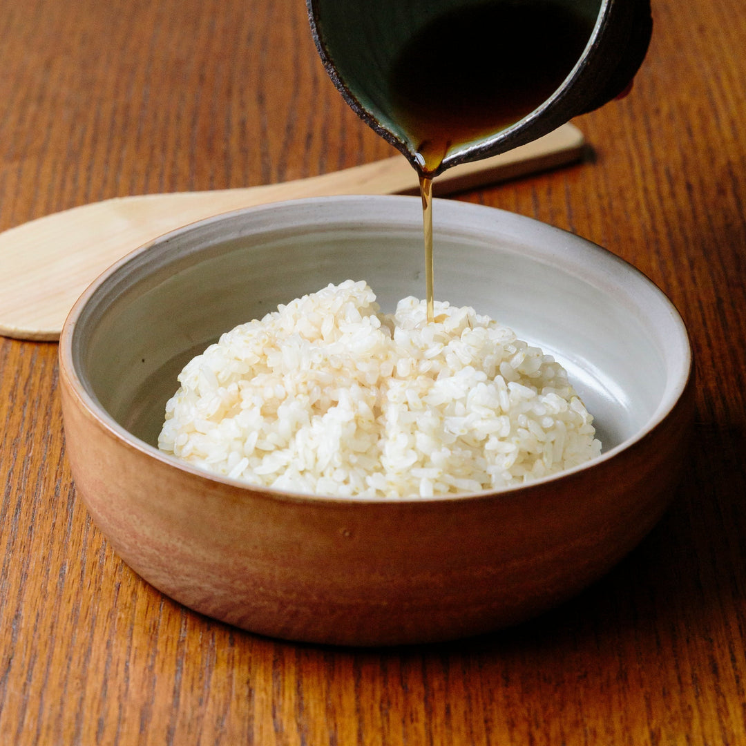 Pouring red vinegar onto cooked rice in a bowl
