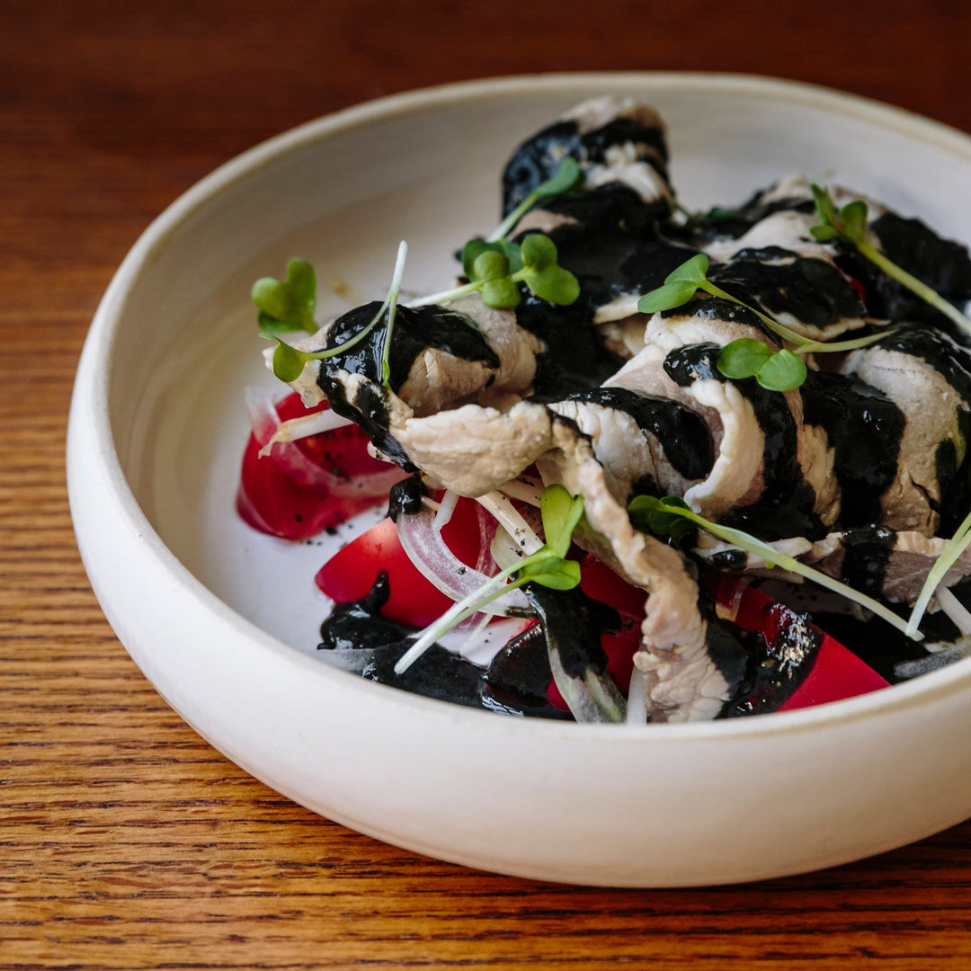 Pork shabu shabu summer salad with heirloom tomatoes, onion, and black sesame