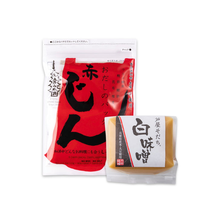 Two packaged Japanese food products on a plain white background: a larger clear stand-up pouch with a bold red label and black calligraphy, and a smaller clear packet with a white label showing a tan rectangular food item. Visible Japanese text appears on both packages, but no clear Latin-script brand name is legible, so visible_brands is left empty.