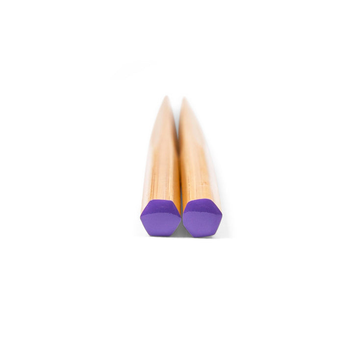 Pair of chopsticks with purple tips on a white background