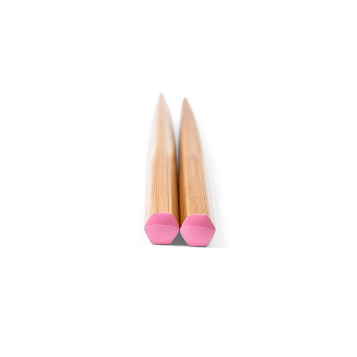 Pair of chopsticks with pink tips on a white background