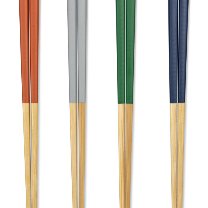 Closeup of a set of four pairs of chopsticks with colored handles on a white background