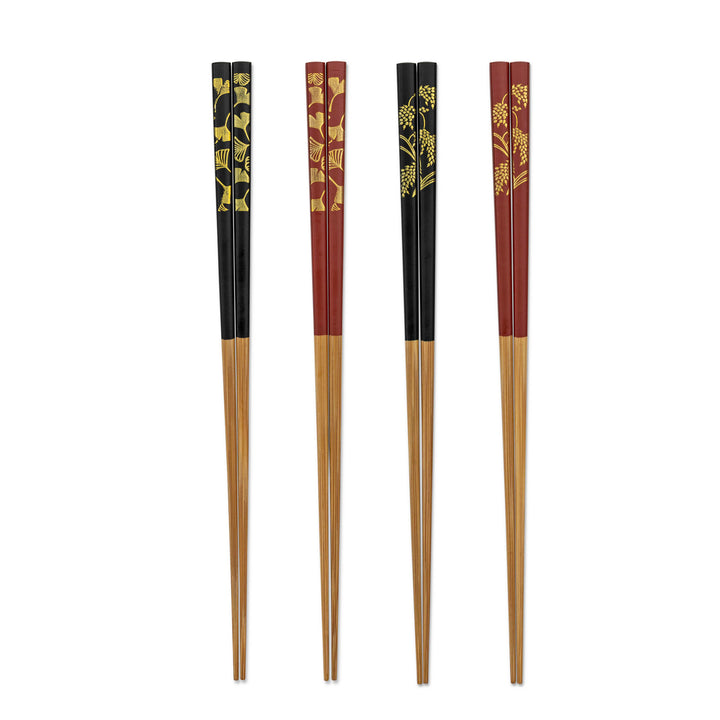 Set of four pairs of chopsticks with black and red handles with gingko and rice stalks on a white background