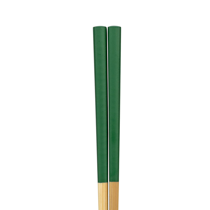 Two wooden chopsticks painted green on a white background