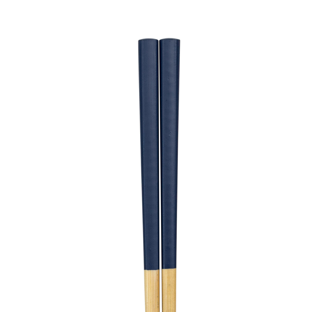 Two wooden chopsticks painted navy blue on a white background