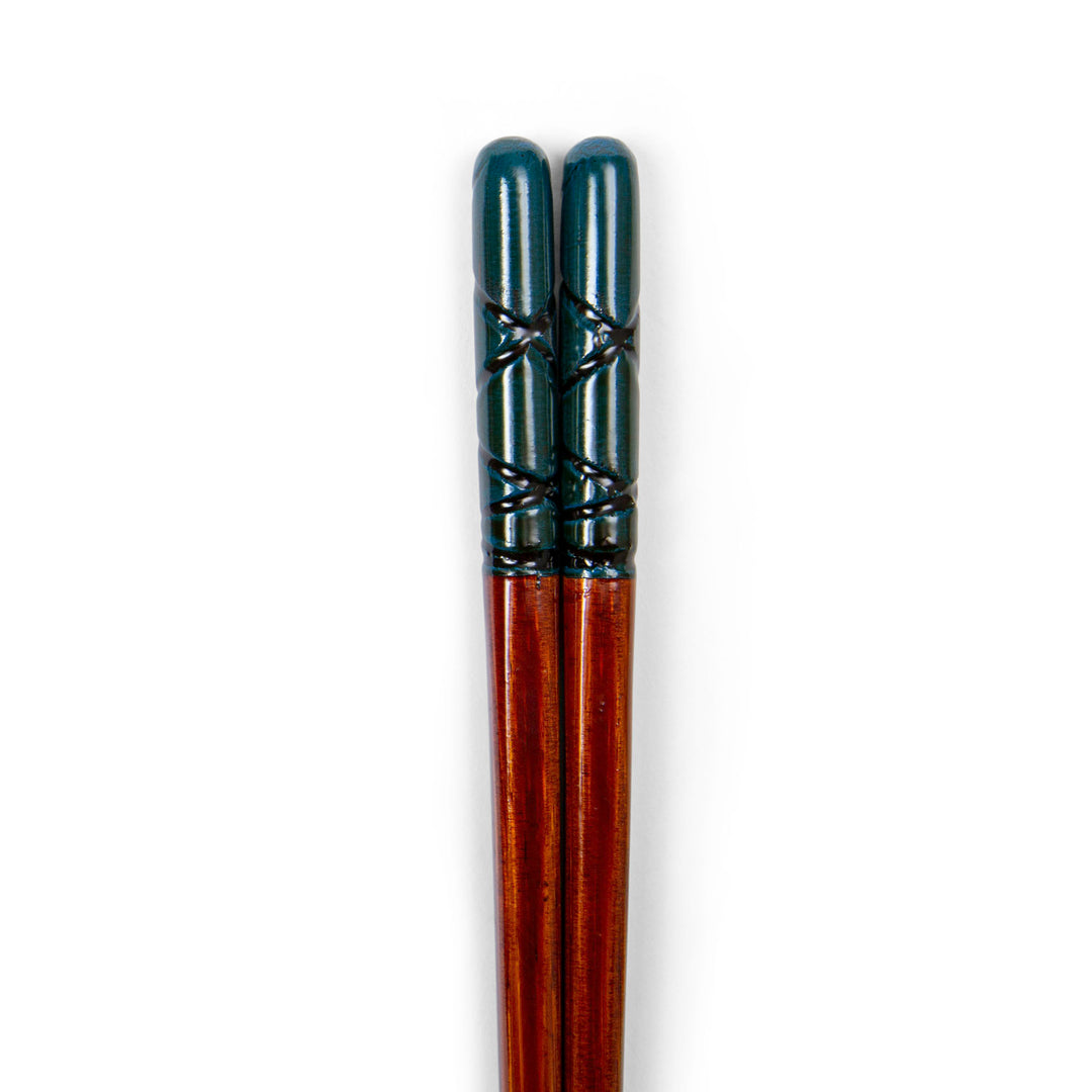 Pair of wooden chopsticks with black ferrules on a white background