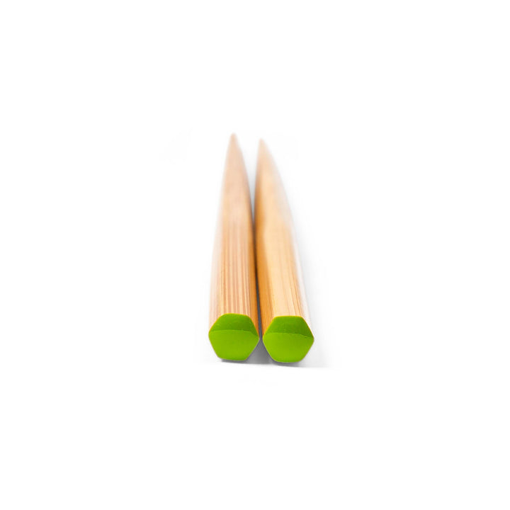 Pair of chopsticks with green tips on a white background