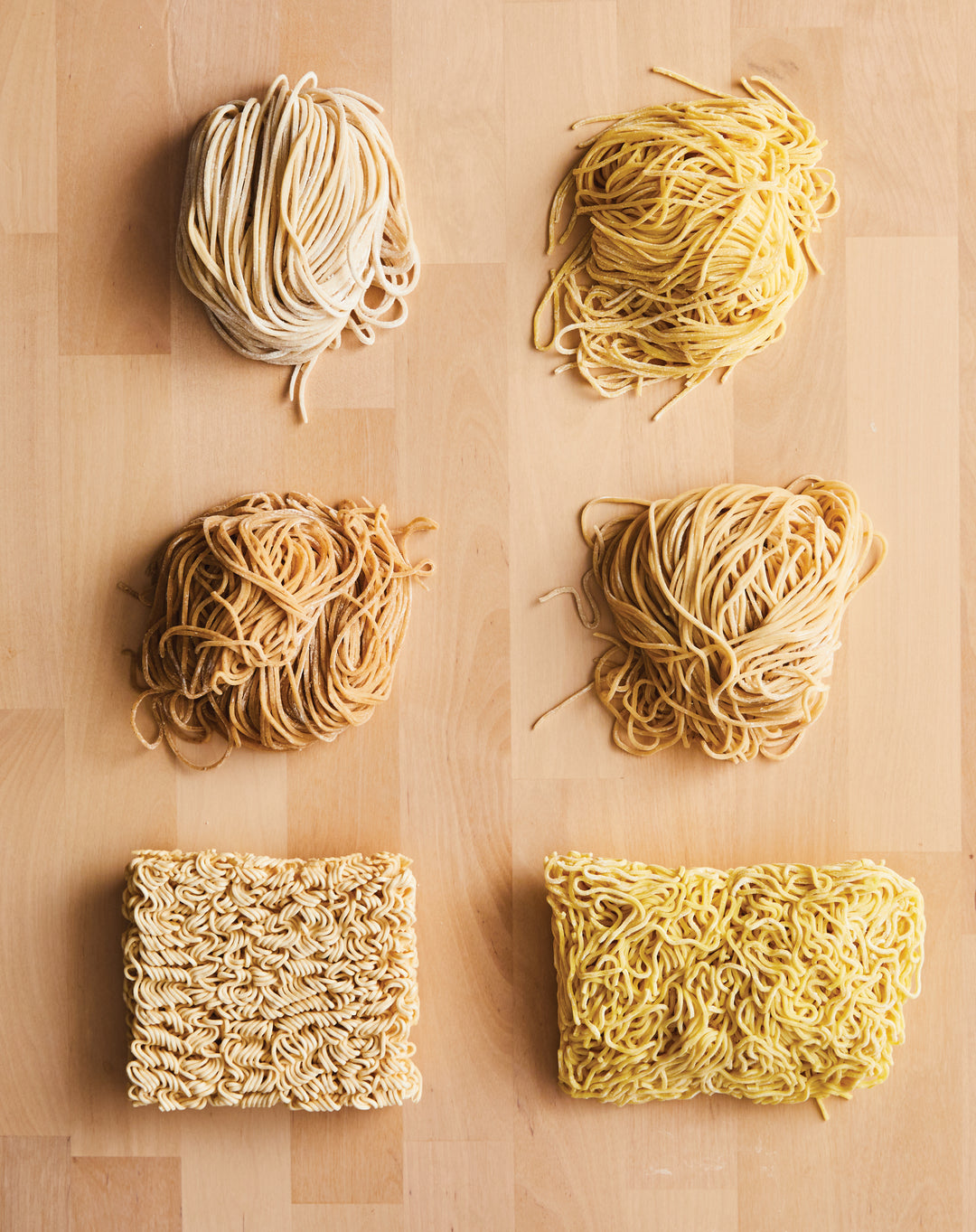 Various types of ramen noodles arranged on a wooden surface