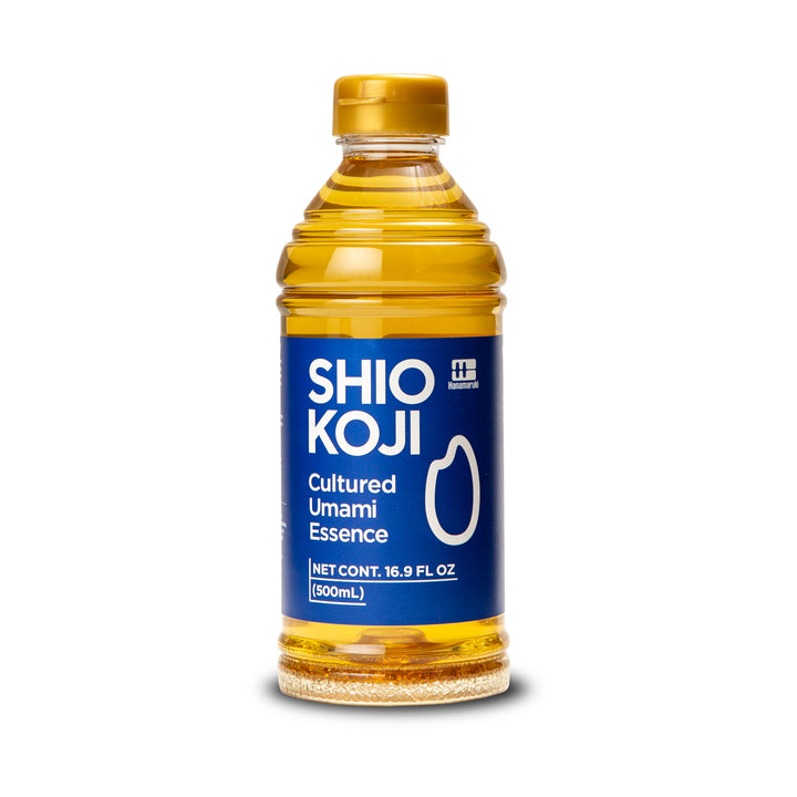 A 16.9 fl oz bottle of Shio Koji Cultured Umami Essence with a blue label and gold cap, shown on a white background with a soft shadow.