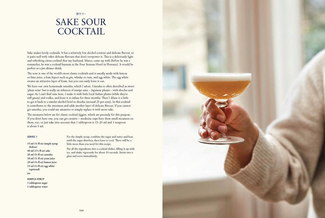 Hand holding a glass of sake sour cocktail with recipe on left side.