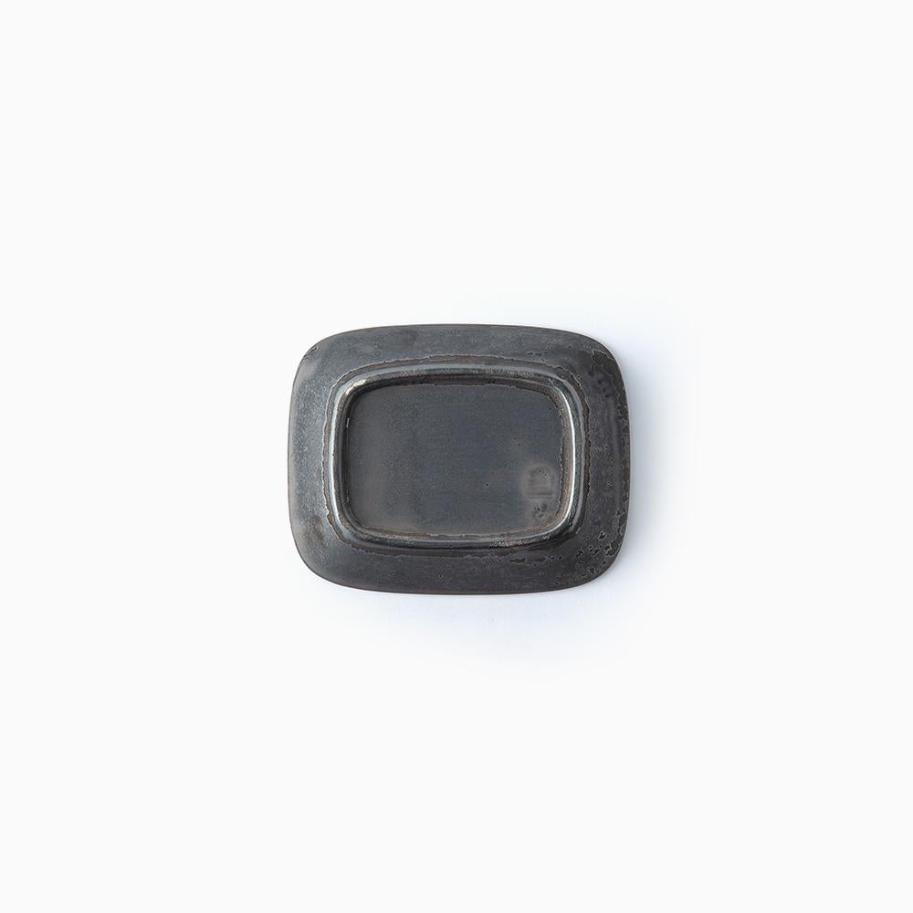 Bottom of small black ceramic bowl on a white background