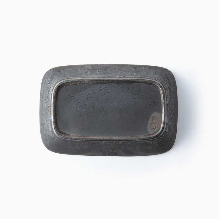 Botton of black mottled rectangular ceramic bowl on a white background